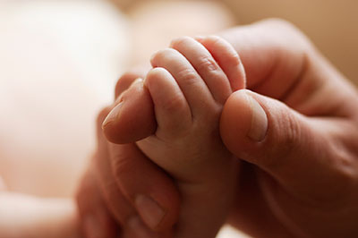 Adult holding baby's hand