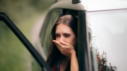 Woman with a short haircut looking back over her shoulder with a shocked and gasp facial expression