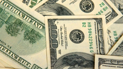 Fanned out one-hundred-dollar bills representing insurance claim deductibles and out-of-pocket costs