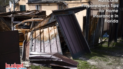 Severe storm and hurricane damage showing a collapsed fence, burnt vehicle, and structural property destruction